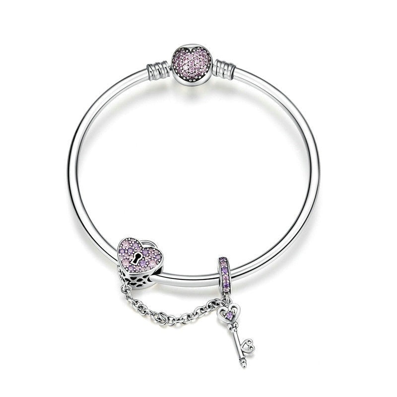 A handmade Pandora charm bracelet adorned with pink crystals, featuring a pink heart lock and key bangle.